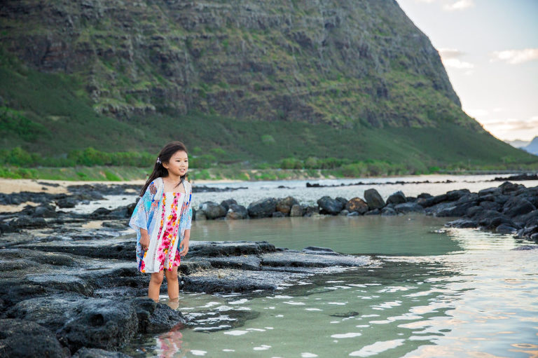 little girl exploring waters edge in East Oahu during family photos