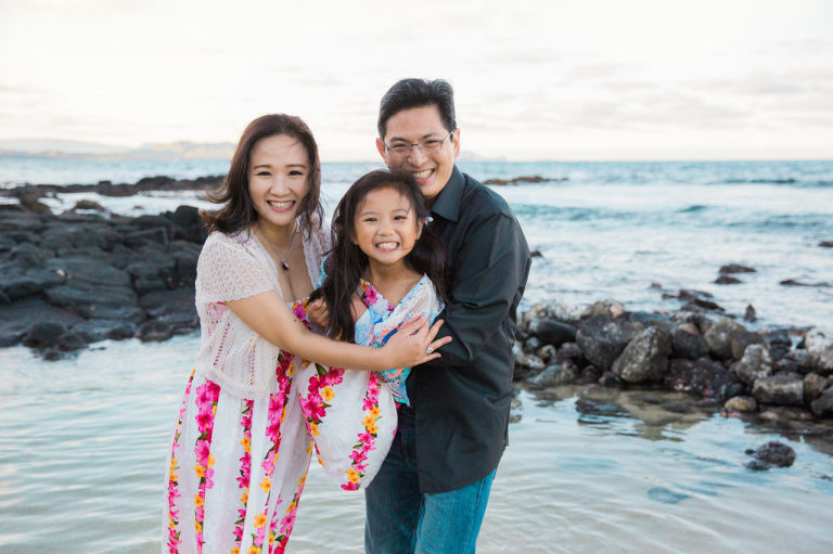 family cuddles in Hawaii beach