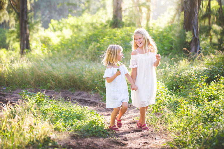 playful and natural photo of girls in hawaiian forest