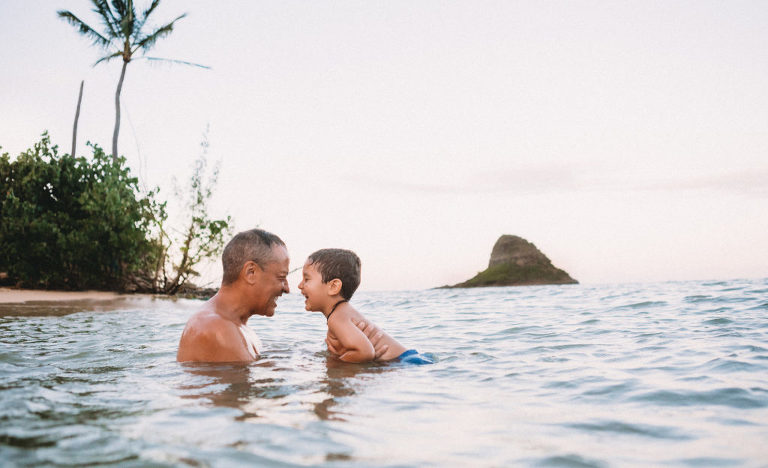 father and son in water during Kualoa Beach photograph