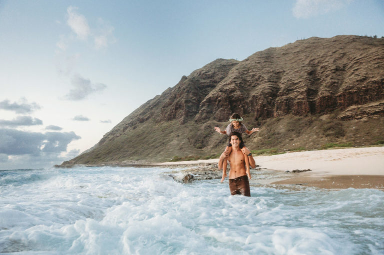 little girl riding on top of dad's shoulder in Hawaii