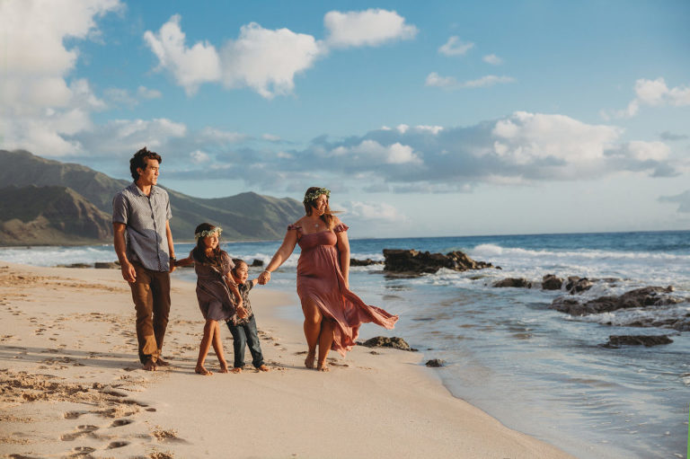 family walking down the Hawaii beach at sunset