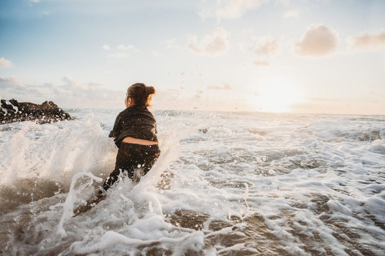 little boy playing in the ocean waves in Hawaii