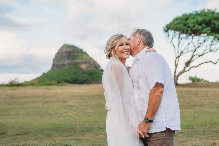 Newlyweds snuggling on north shore kualoa beach