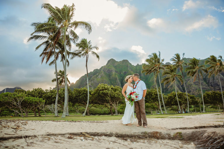 newlywed wedding portrait with palm trees and mountains