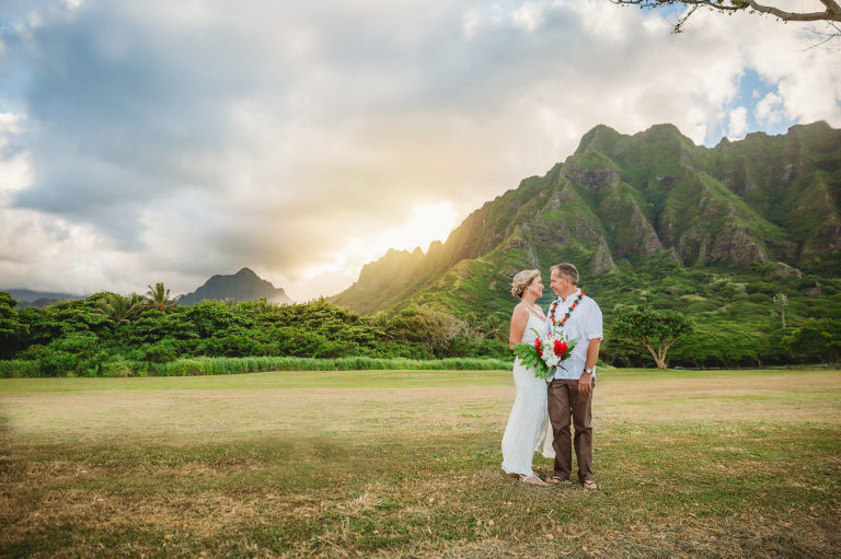 Beautiful wedding portrait of a couple with Hawaiian mountains behind them