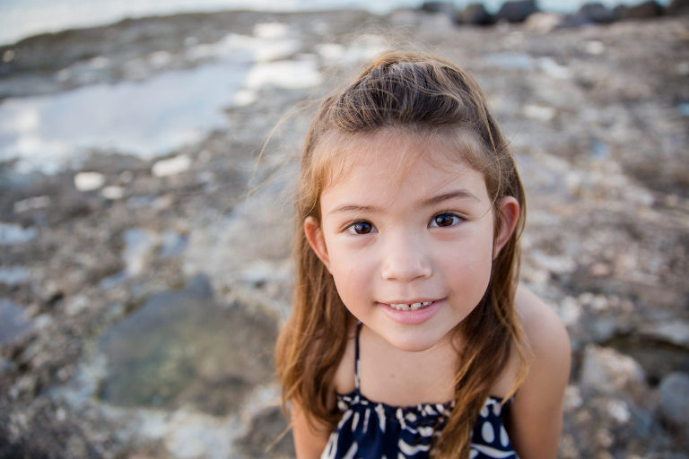 young girl peering into the photographerʻs camera