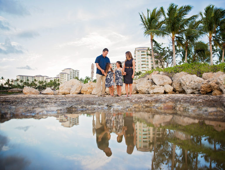 family standing near the ocean edge with Ko Olina in the background